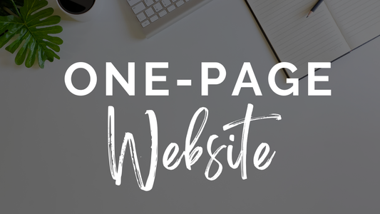 Keyboard, notebook, pen, coffee, and plant on a desk with the text "One-Page Wonder" overlaid in large bold font—a high-quality one-page website solution by Socially Inclined.